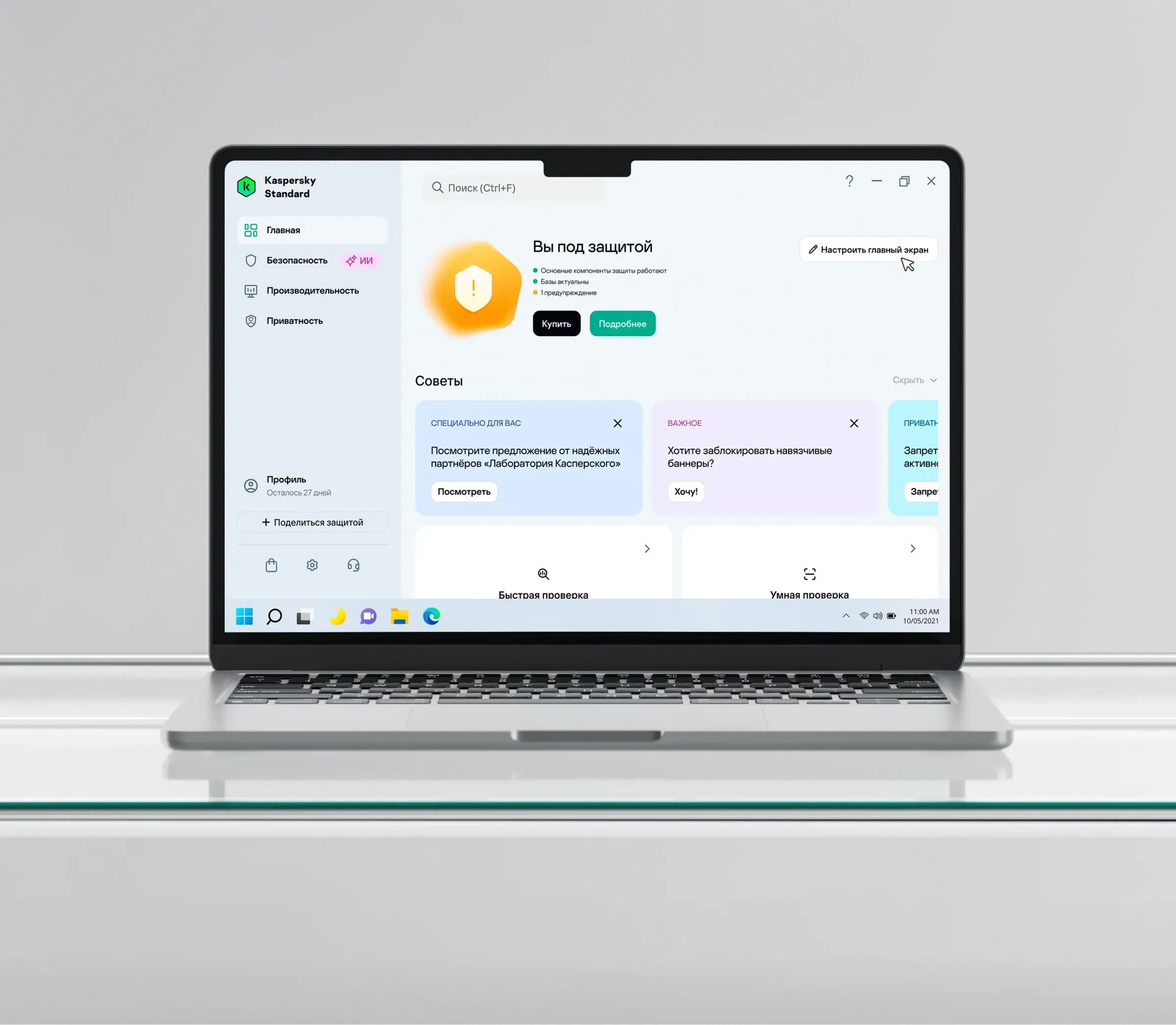 Ноутбук с приложением Kaspersky Standard в окне Windows: раздел «Главная» с блоком «Вы под защитой», карточками советов и кнопкой «Настроить главный экран», внизу экрана — панель задач.